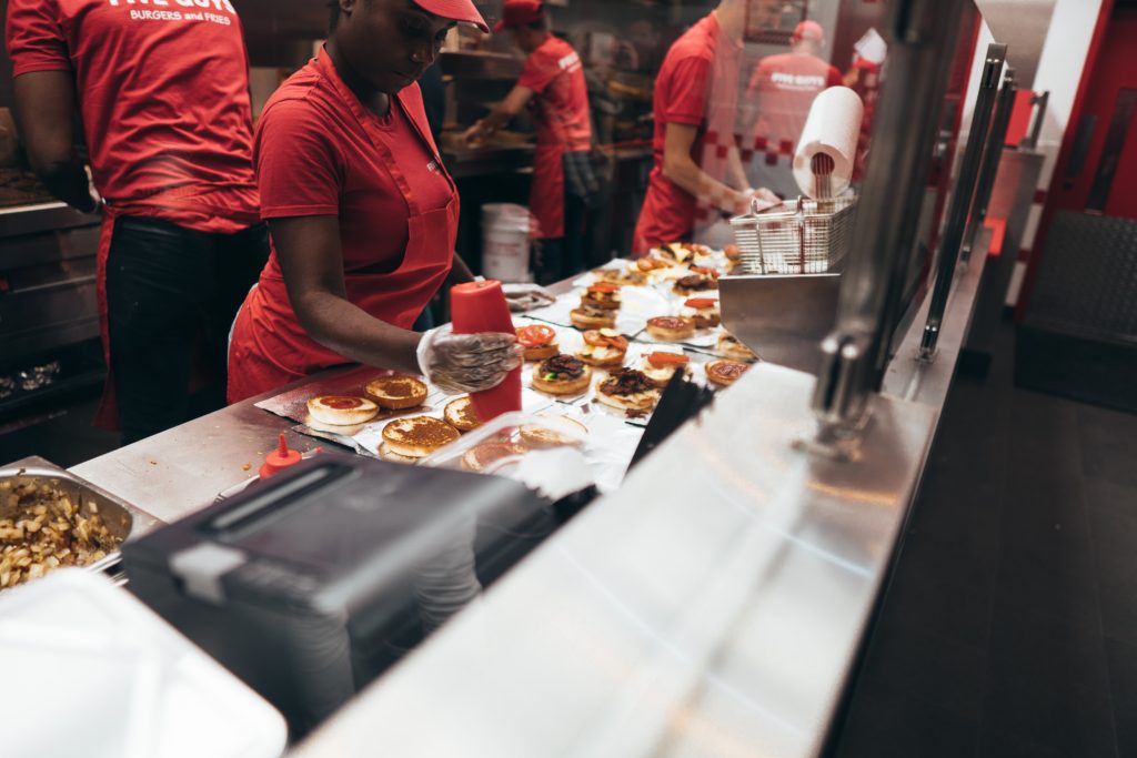 Fast food workers assemble burgers.