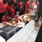 Fast food workers assemble burgers.